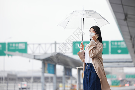 整理行李箱戴口罩在机场打车的女性背景