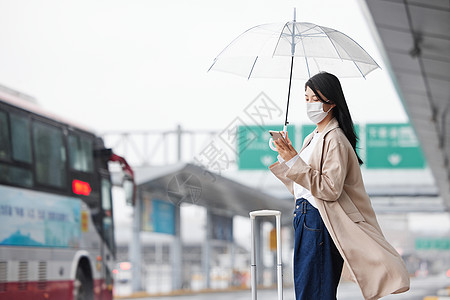 春天戴口罩疫情期间戴口罩等车的女性背景