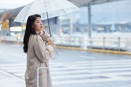 雨天撑伞等车的女性高清图片