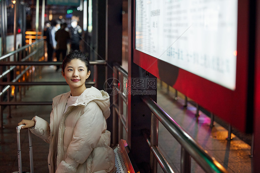 美女夜间出行坐在站台等待公交车