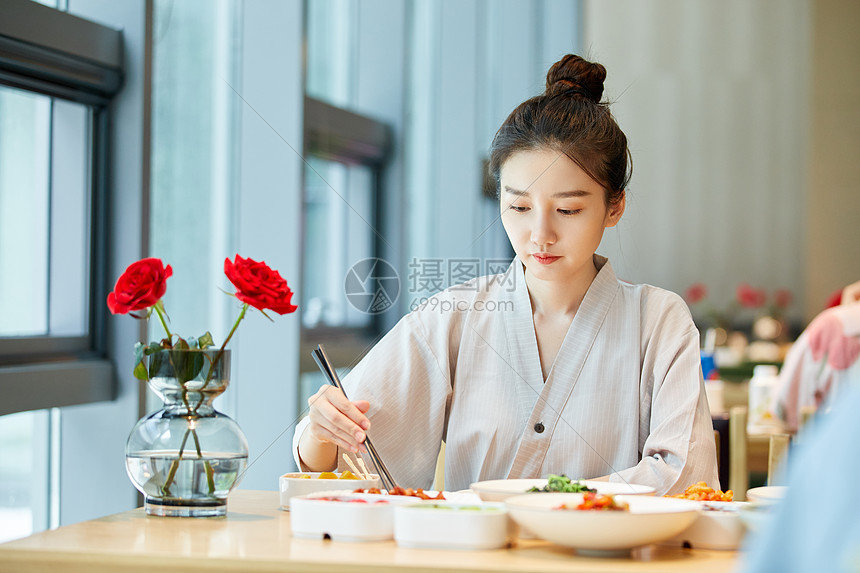 年轻美女在汤泉馆美食区吃饭图片