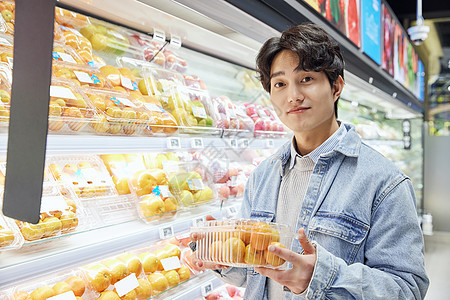 青年男性逛生鲜超市挑选水果背景图片
