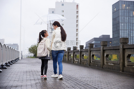 下雨天妈妈接送女儿上学图片