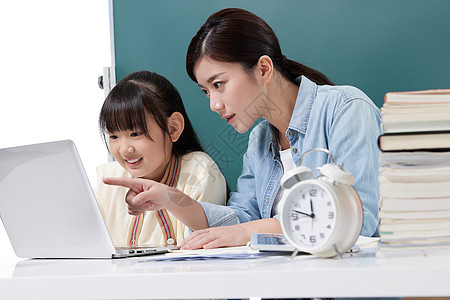 女性教师辅导小学生学习图片