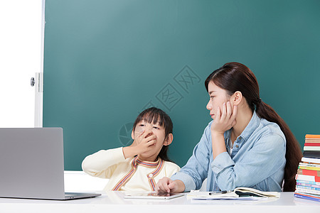 家长辅导困倦的女儿小学生学习图片