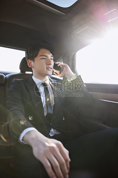商务精英男士坐在轿车里打电话图片