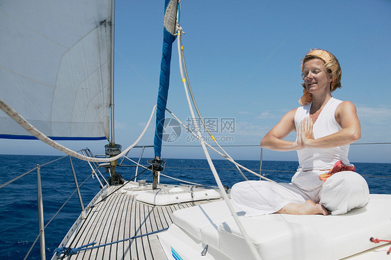 妇女在帆船上做瑜伽图片