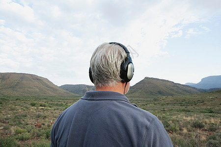 戴耳机听音乐的男人背影背景图片