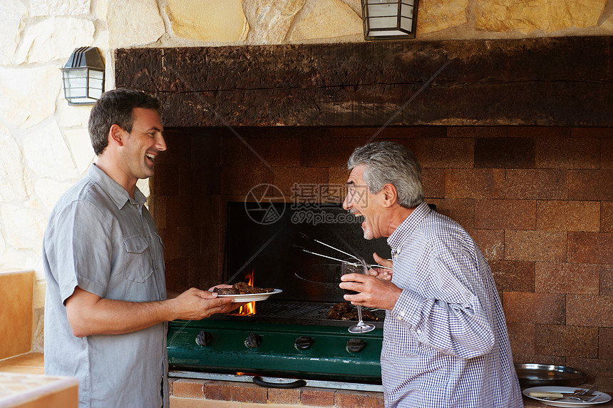两个男人开心的做烧烤图片