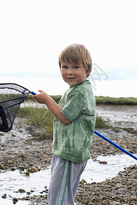 抱渔网的年轻男孩图片