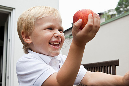  男孩手里握着苹果背景图片