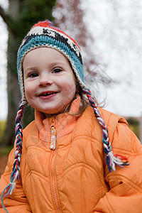 身穿编织帽和橙色夹克的女孩图片