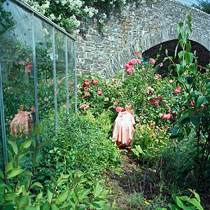 女孩在温室花朵中玩图片