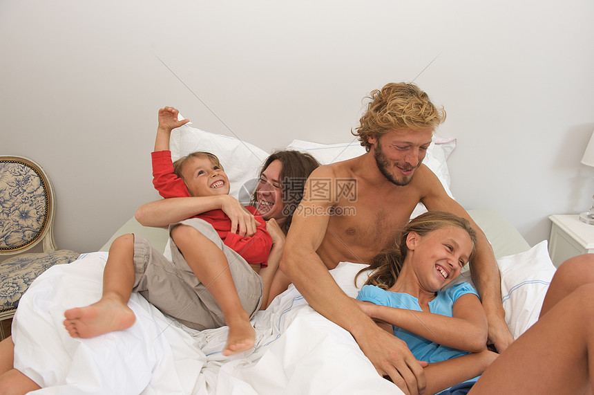 年轻家庭在父母床上玩乐图片