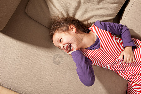 小女孩躺在沙发上笑着图片