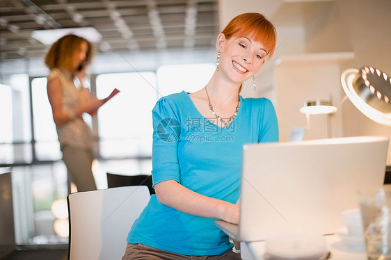 办公室使用笔记本电脑的女商人图片