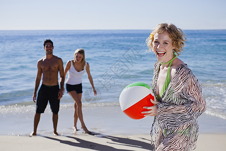 女人在海滩上带着球图片