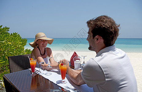 夫妻在海滩的甲板上吃饭图片