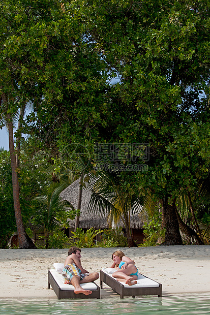 情侣在沙滩椅上放松图片