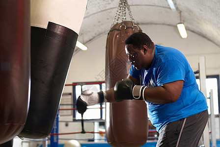 拳击手在健身房使用拳击袋图片