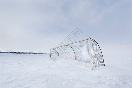 雪覆盖田中的曲棍球网图片