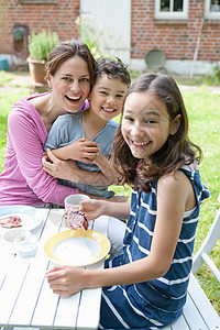母亲和儿童在户外吃饭图片