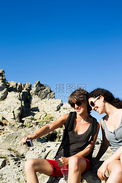 两个女性在坐在岩石上自拍图片
