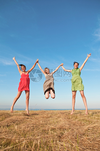 三个女孩在小麦田中玩耍图片