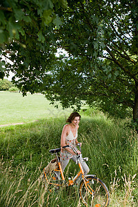 美女草丛里推自行车图片