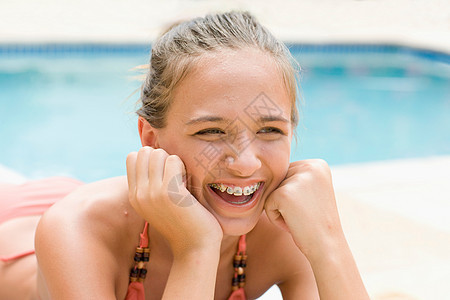 戴牙套的少女在游泳池大笑图片