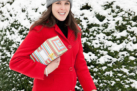 在雪中携带包装礼物的女性图片