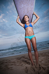 女人举起冲浪板图片