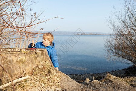 男孩在湖边玩浆果图片