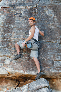 攀爬者徒手攀爬陡峭的岩石图片