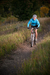 泥土路上骑山地自行车的人图片