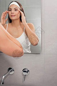 女人用镜子检查她的脸图片