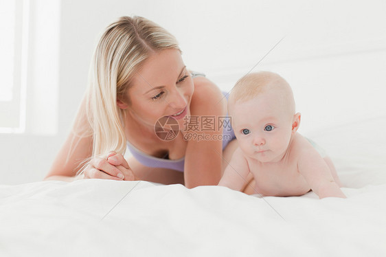 母亲和婴儿躺在床上图片
