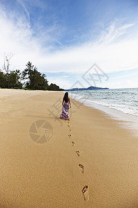 妇女在沙滩上留下脚印图片