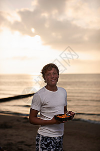 少年男孩在海滩边吃东西图片