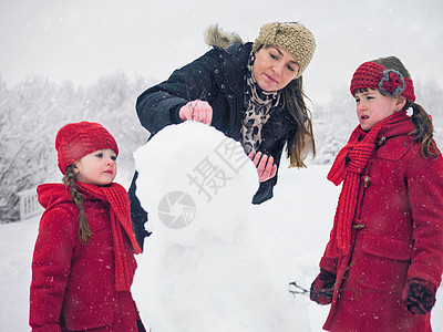 母亲和女儿在堆雪人图片