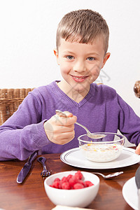 男孩子在餐桌上吃早图片