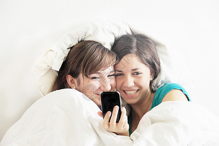 在床上使用手机的少女图片