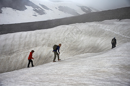 家庭在雪山坡上徒步图片