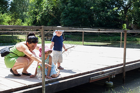 母亲和孩子在河岸边玩耍图片