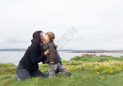 母亲和儿子在草地亲吻图片