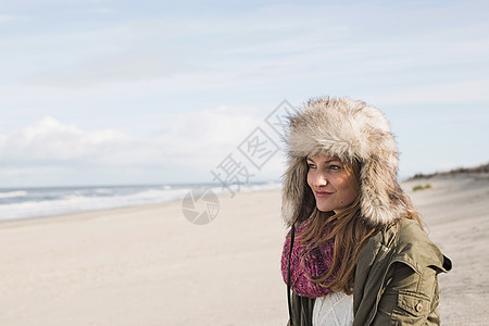 微笑的女人站在沙滩上图片