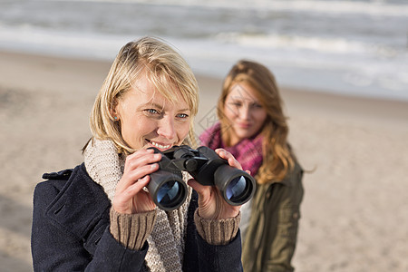 海滩上使用望远镜的妇女图片