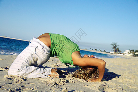 妇女在热带海滩上做瑜伽图片