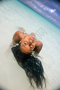 躺在沙滩水中的女性图片