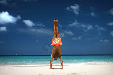 一个人在热带沙滩上做倒立图片